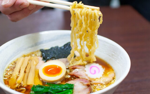 香ばしい醤油スープに浸る、2種類の炭火焼きチャーシュー。飲食業一筋